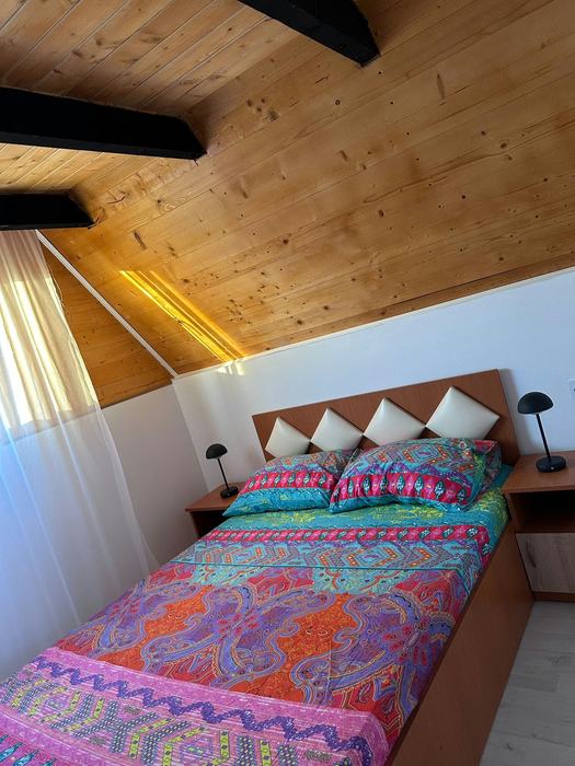 Dormitor cu pat dublu și tavan din lemn